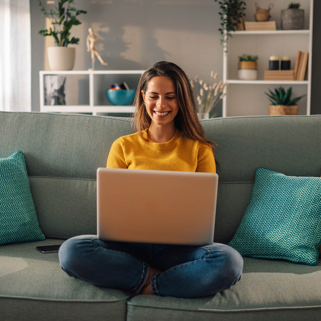 Frau sitzt am Laptop und tippt